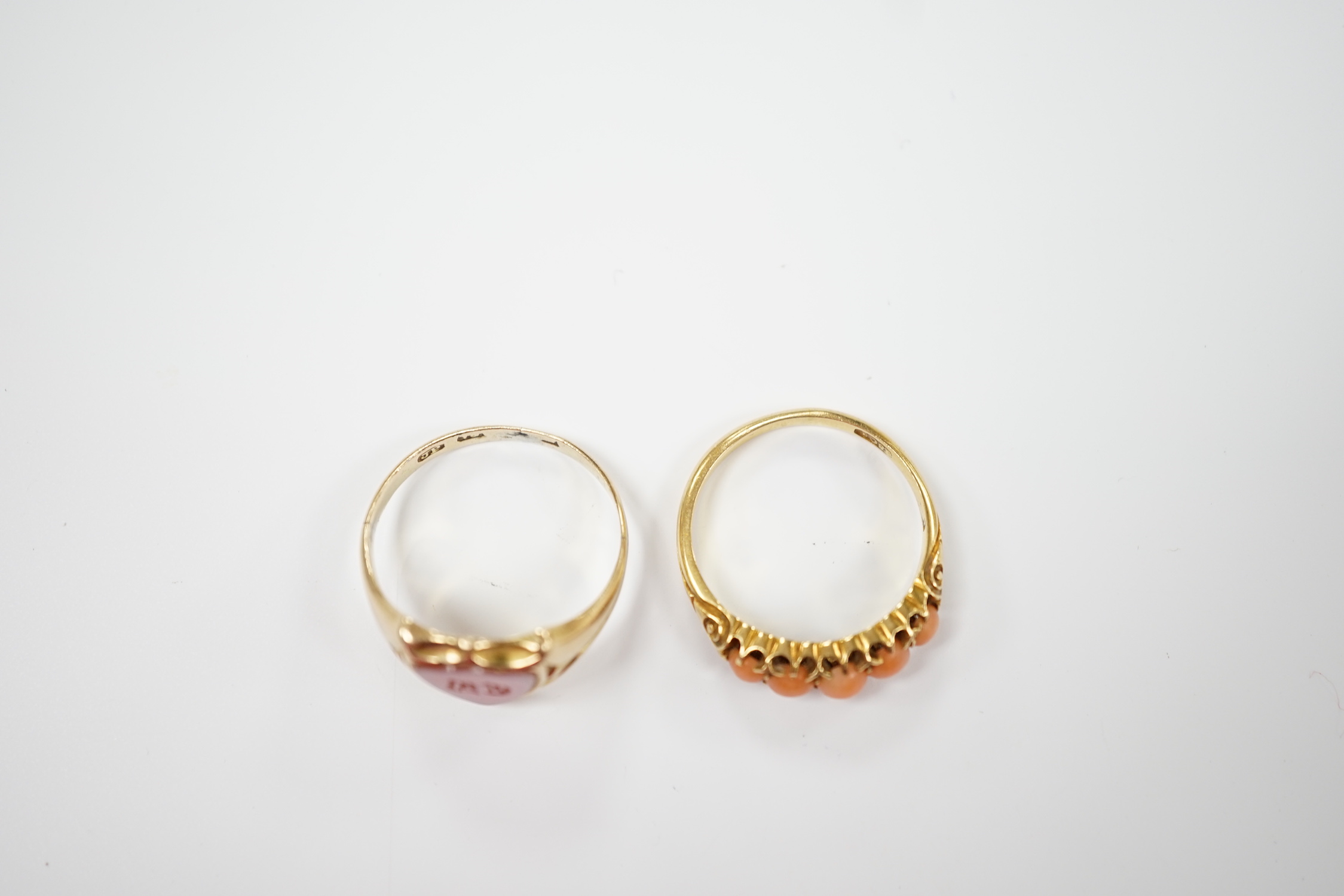 An early 20th century 18ct and graduated five stone split coral bead set half hoop ring, size O and a Victorian 12ct gold and sardonyx set shield shaped signet ring, size Q.